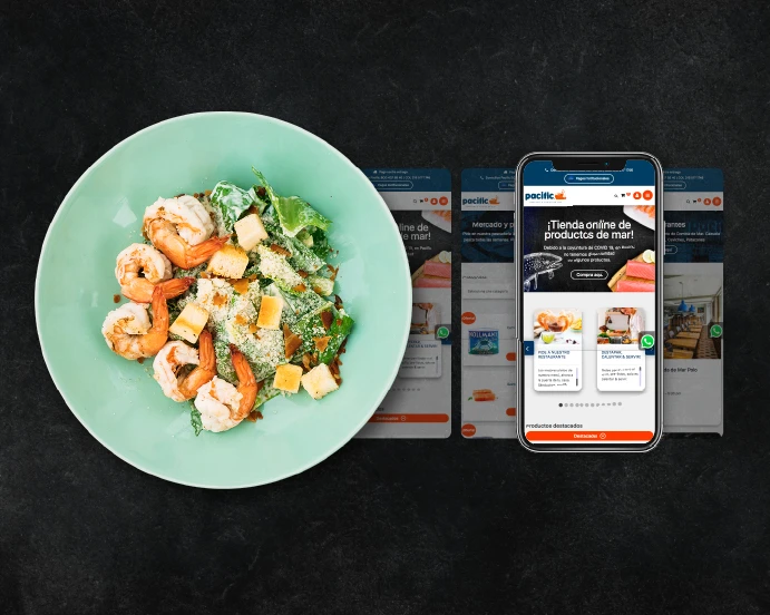 pagina principal de pacific visualizado en un smartphone junto a un plato de comida de mar